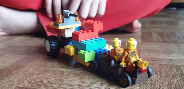Midsection of child playing with toy car on floor