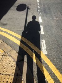 Shadow of man on road