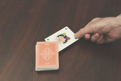 Cropped image of hand playing with cards