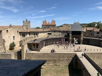 People in historic building against sky