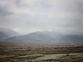 Scenic view of mountains against cloudy sky