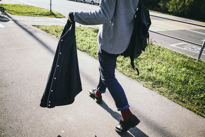 Low section of man walking on sidewalk