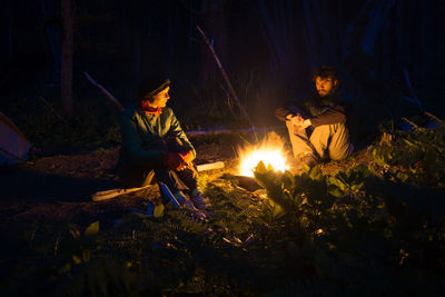 Couple by bonfire at night