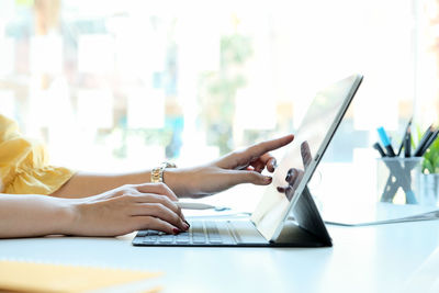 Midsection of woman using laptop on table