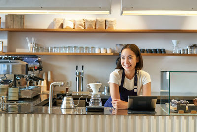 Young woman using mobile phone in cafe