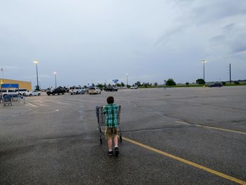 Rear view of man walking on road