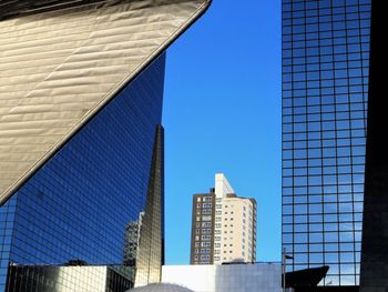 Low angle view of modern buildings against clear blue sky