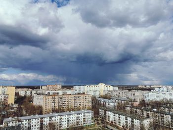 Buildings in city against cloudy sky