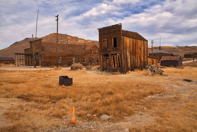 Old abandoned building on field against sky