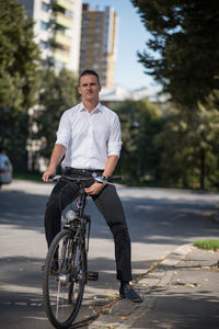 Man riding bicycle on road in city