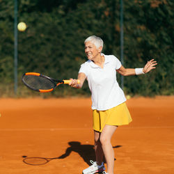 Full length of woman playing with ball