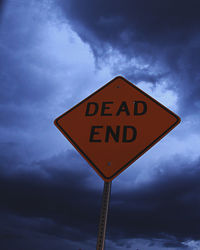 Low angle view of road sign against sky