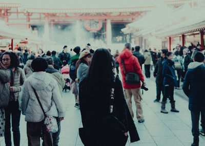 Rear view of people walking in city