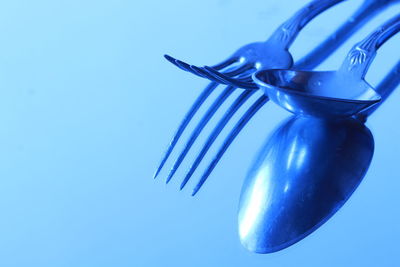 Close-up of wineglass on table against blue background