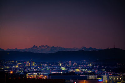 High angle view of illuminated city against sky at sunset