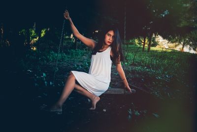 Portrait of woman sitting on swing