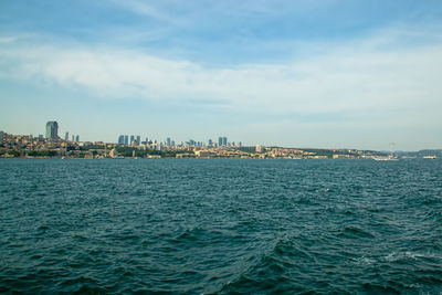 Sea by buildings against sky in city