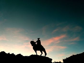 Low angle view of silhouette dog against sky during sunset