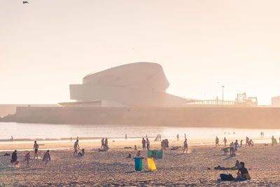 People on beach against clear sky