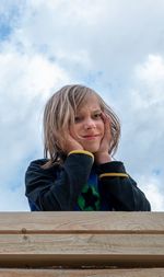 Portrait of smiling girl against cloudy sky