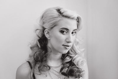 Portrait of young woman against white background