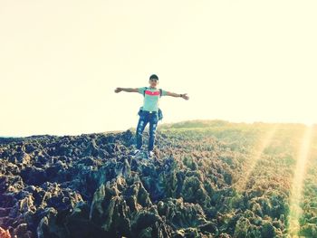 Full length of man standing on field against clear sky