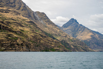 Scenic view of sea and mountains against sky