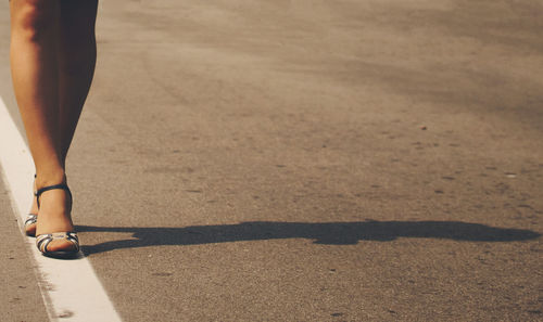 Low section of woman standing on road