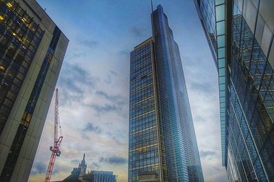 Low angle view of modern building against cloudy sky