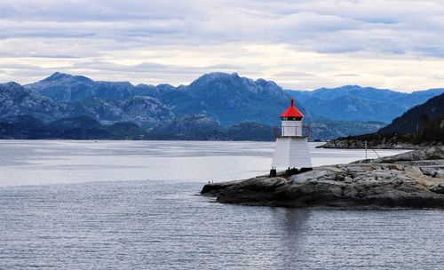 Lighthouse by sea against sky