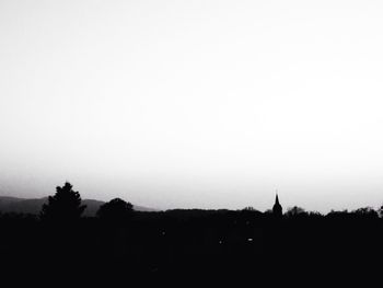 Silhouette trees on landscape against sky