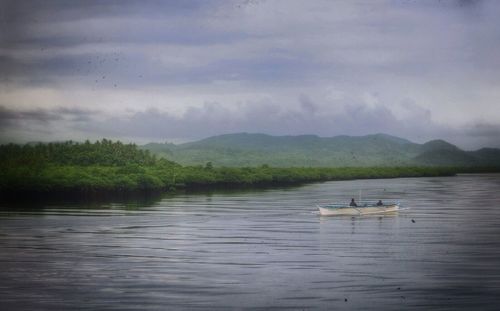 Scenic view of lake against cloudy sky