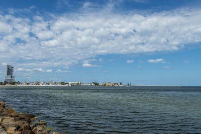 Scenic view of sea by buildings against sky