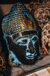 Handmade blue gold plated buddha face mask on a counter in a street shop on the island of bali