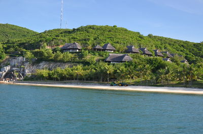 Houses by sea against sky