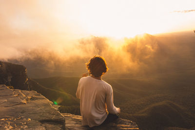 Rear view of woman looking at sunset