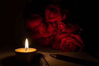 Close-up of lit candle in darkroom