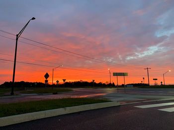 Empty road against dramatic sky during sunset