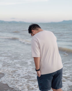 Young man standing at beach