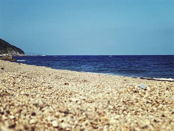 Surface level of beach against clear sky