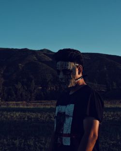 Man standing on mountain against clear sky