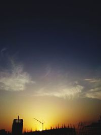 Low angle view of crane against sky at sunset