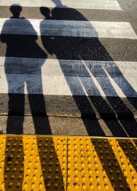 Shadow of people standing on road