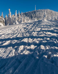 Snow covered mountain against blue sky