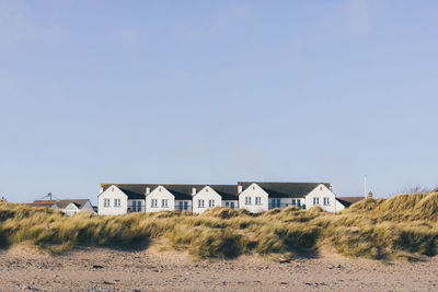 Houses on field against clear sky