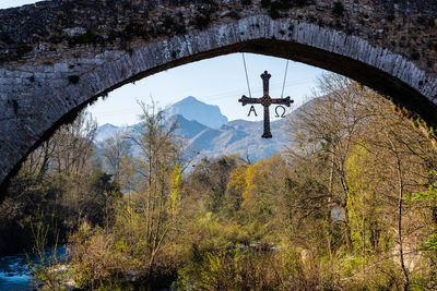 Cross hanging from old roman stone bridge. cangas de onis, asturias, spain. concept religion, faith