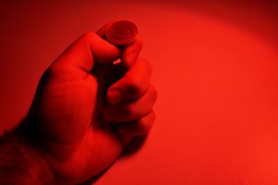 Close-up of human hand against red background