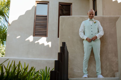 Portrait of man standing against building