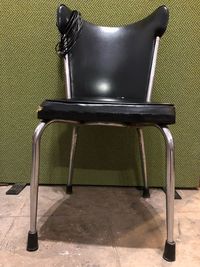 Empty chairs and table against wall