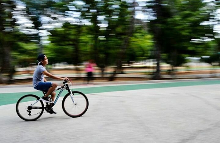 YOUNG MAN RIDING BICYCLE ON ROAD